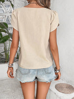 Top monocolore estivo con scollo asimmetrico e maniche a sbuffo perfetto per le vacanze