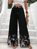 Pantaloni a gamba larga a vita alta con stampa floreale e dettaglio di fiocco sul davanti per donne, neri