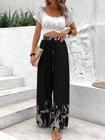 Pantaloni a gamba larga a vita alta con stampa floreale e dettaglio di fiocco sul davanti per donne, neri