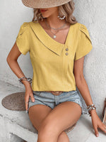 Top monocolore estivo con scollo asimmetrico e maniche a sbuffo perfetto per le vacanze