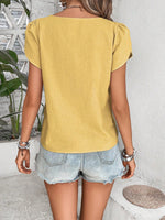 Top monocolore estivo con scollo asimmetrico e maniche a sbuffo perfetto per le vacanze