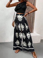 Top canotta asimmetrica con volant e spallina singola e pantaloni a gamba larga con stampa hawaiana