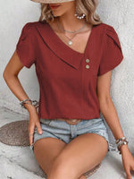 Top monocolore estivo con scollo asimmetrico e maniche a sbuffo perfetto per le vacanze