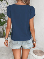 Top monocolore estivo con scollo asimmetrico e maniche a sbuffo perfetto per le vacanze