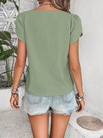 Top monocolore estivo con scollo asimmetrico e maniche a sbuffo perfetto per le vacanze