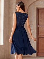 Vestito svasato da cocktail party in chiffon con inserti di paillettes e rifiniture a balze