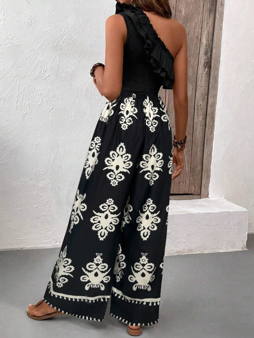 Top canotta asimmetrica con volant e spallina singola e pantaloni a gamba larga con stampa hawaiana