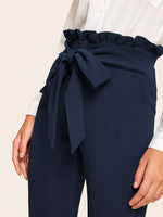 Pantaloni skinny con nodo e vita a volant sovrapposti